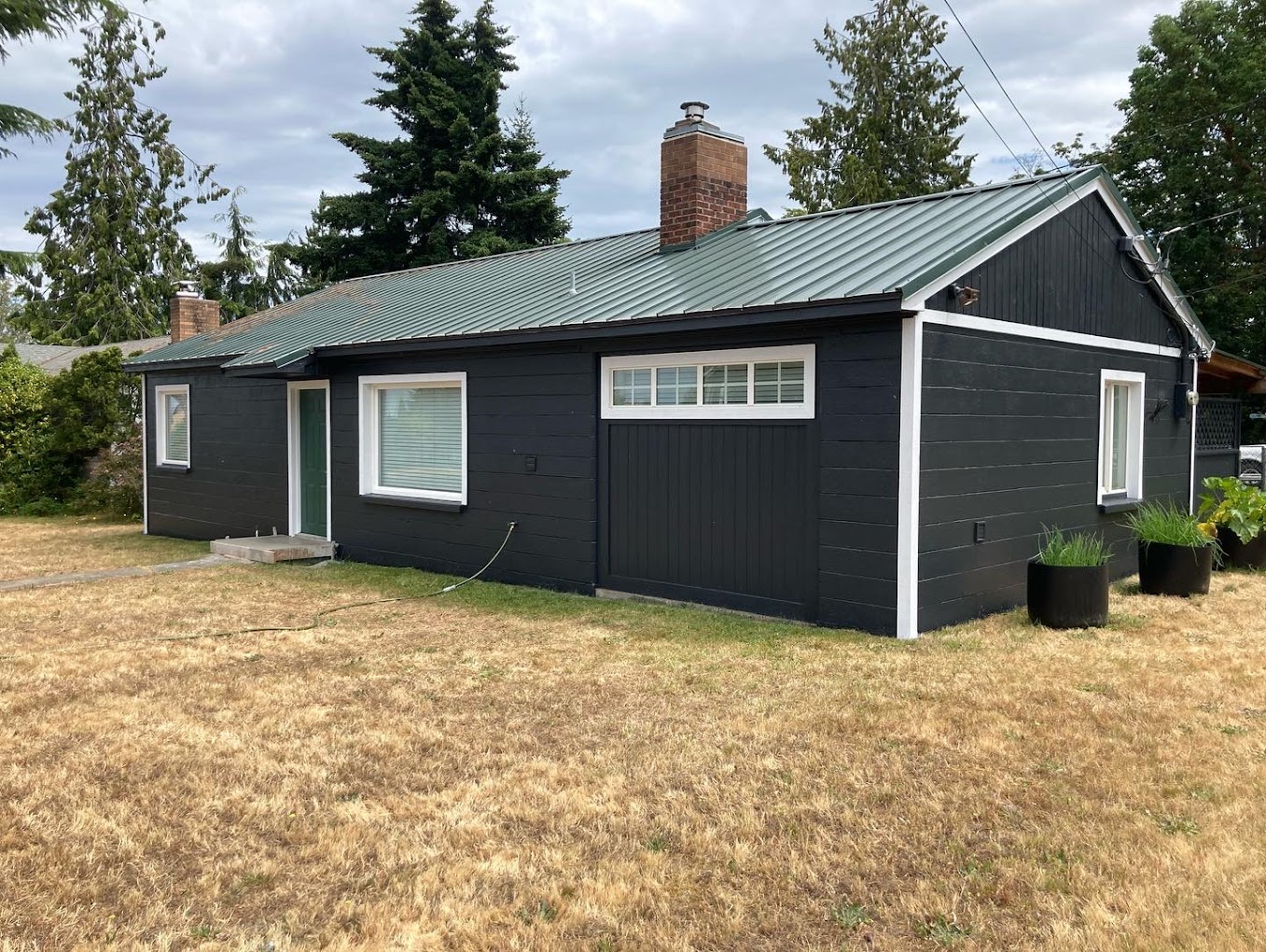 Small Cinder Block Home, Port Angeles 2022, Black with white trim with a green door for a pop of color