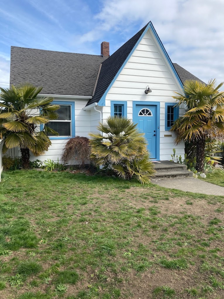 Adorable small home exterior in Port Angeles, White body pait with blue trim.